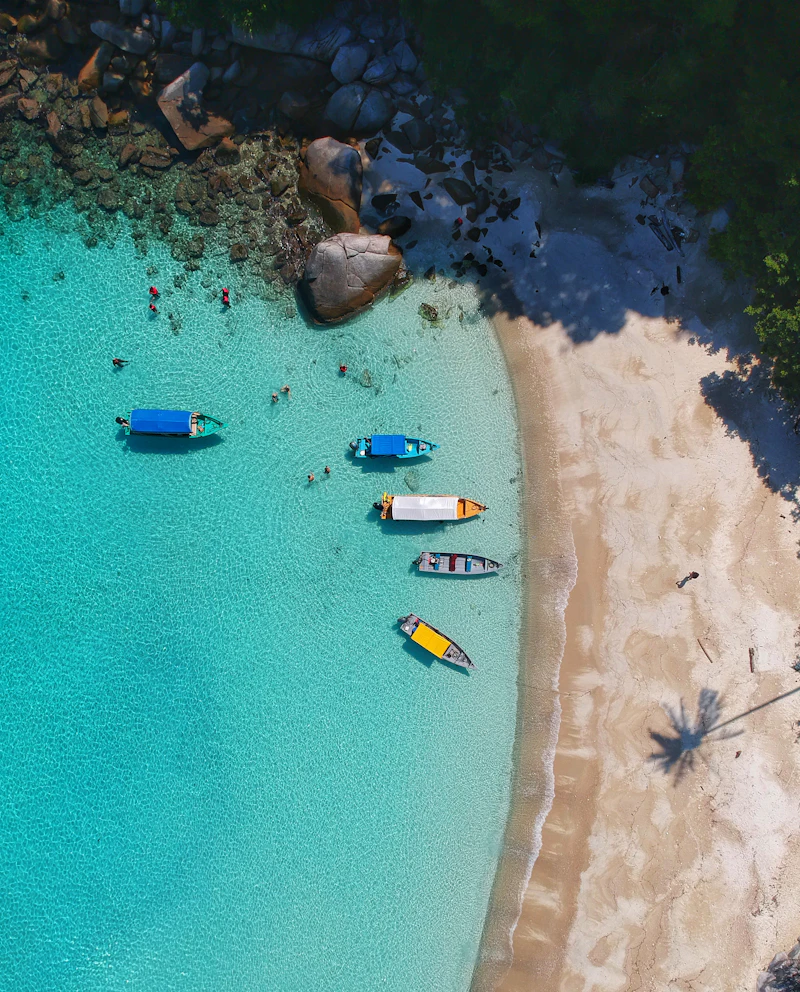 Agua turquesa y lanchas junto a una playa de arena blanca